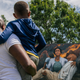 Nehemiah Frank, left, teaches his cousin David McIntye II of the Tulsa massacre, in the Greenwood district, on May 28, 2021 in Tulsa, Oklahoma.